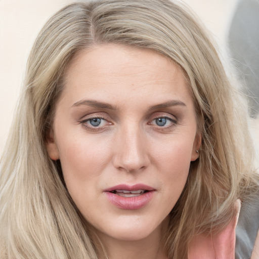 Joyful white young-adult female with long  brown hair and blue eyes