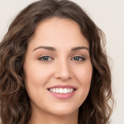 Joyful white young-adult female with long  brown hair and green eyes