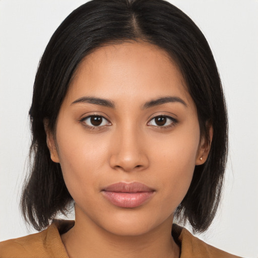 Joyful latino young-adult female with medium  brown hair and brown eyes