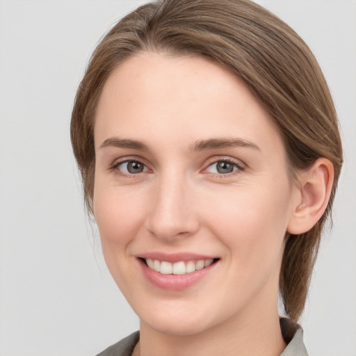 Joyful white young-adult female with medium  brown hair and grey eyes