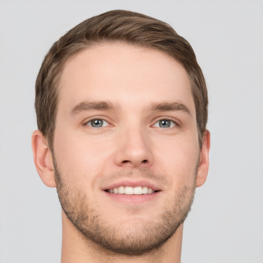 Joyful white young-adult male with short  brown hair and grey eyes