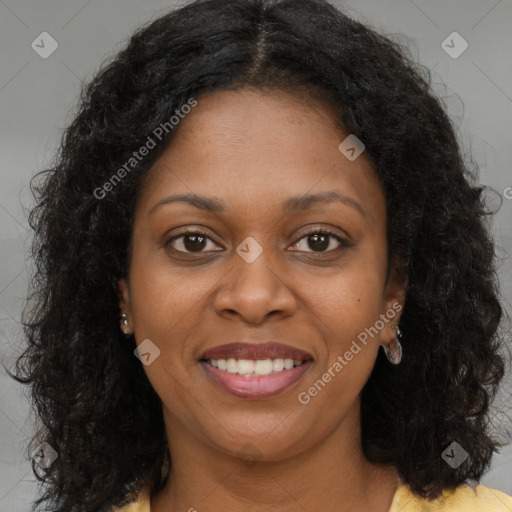 Joyful black young-adult female with long  brown hair and brown eyes