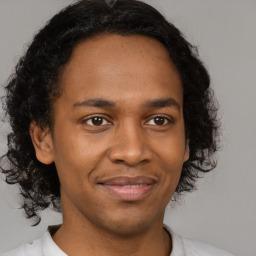 Joyful latino young-adult male with short  brown hair and brown eyes