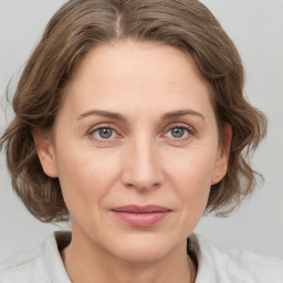 Joyful white adult female with medium  brown hair and grey eyes