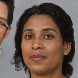 Joyful black adult female with medium  brown hair and brown eyes