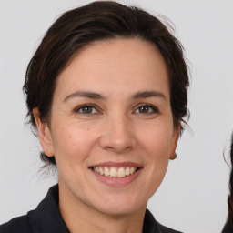 Joyful white adult female with medium  brown hair and brown eyes