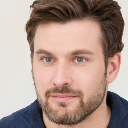 Joyful white young-adult male with short  brown hair and grey eyes