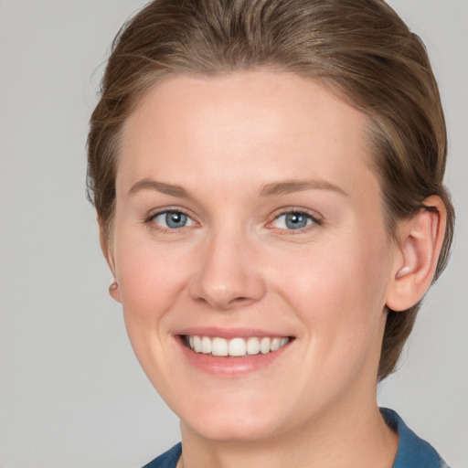 Joyful white young-adult female with medium  brown hair and blue eyes