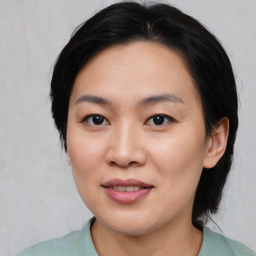 Joyful asian young-adult female with medium  black hair and brown eyes