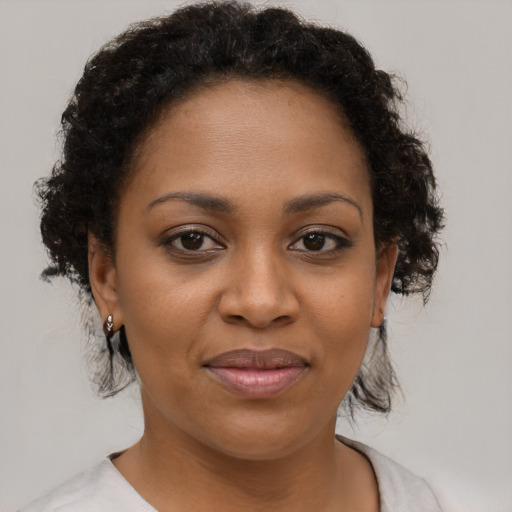Joyful black young-adult female with short  brown hair and brown eyes