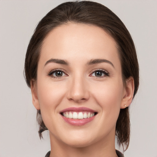 Joyful white young-adult female with medium  brown hair and grey eyes