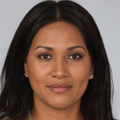 Joyful black young-adult female with long  brown hair and brown eyes