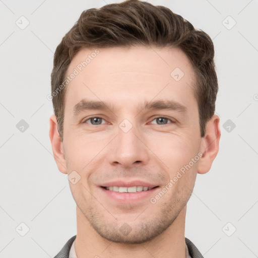 Joyful white young-adult male with short  brown hair and grey eyes