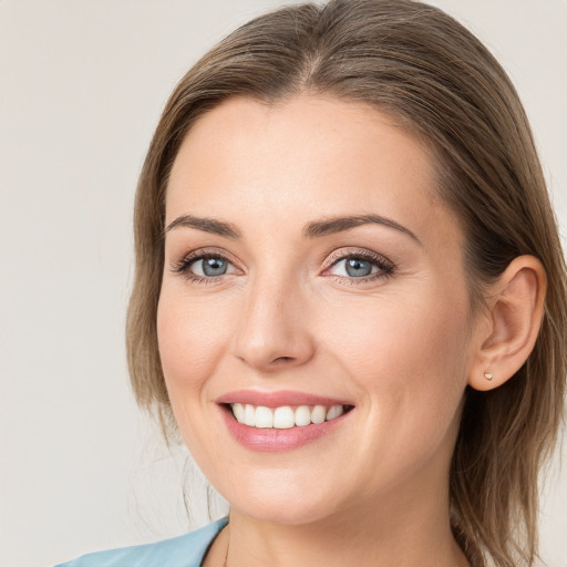 Joyful white young-adult female with long  brown hair and blue eyes