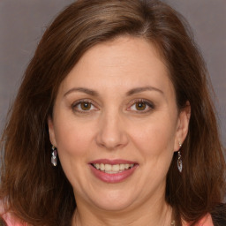 Joyful white adult female with long  brown hair and brown eyes