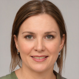 Joyful white young-adult female with medium  brown hair and grey eyes