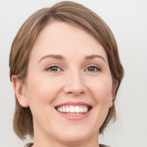 Joyful white young-adult female with medium  brown hair and green eyes