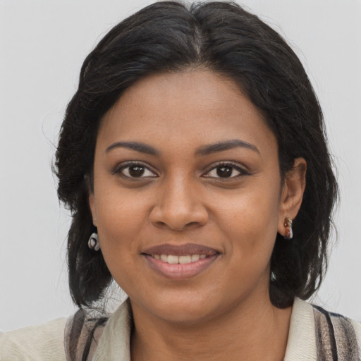 Joyful black young-adult female with long  brown hair and brown eyes