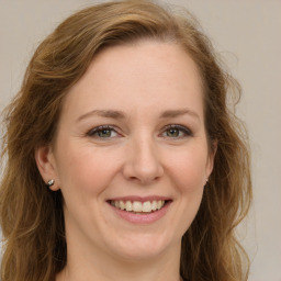 Joyful white young-adult female with long  brown hair and green eyes