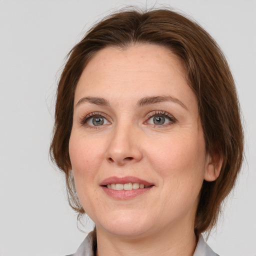 Joyful white adult female with medium  brown hair and grey eyes