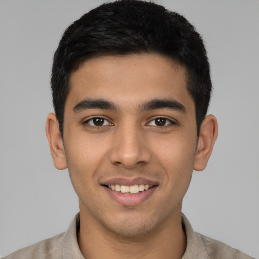 Joyful latino young-adult male with short  brown hair and brown eyes