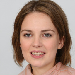 Joyful white young-adult female with medium  brown hair and blue eyes