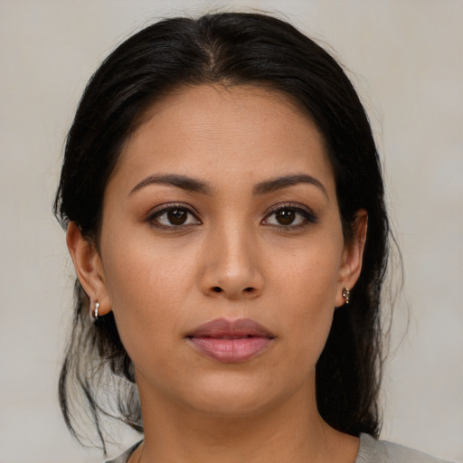 Joyful latino young-adult female with medium  brown hair and brown eyes