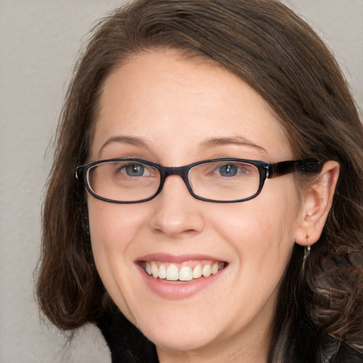 Joyful white adult female with long  brown hair and grey eyes