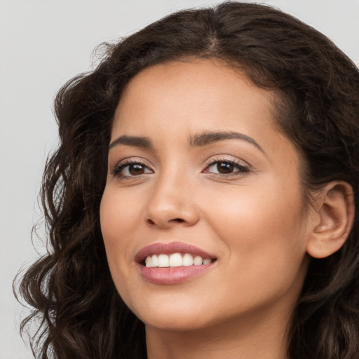 Joyful white young-adult female with long  brown hair and brown eyes