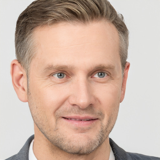 Joyful white adult male with short  brown hair and grey eyes