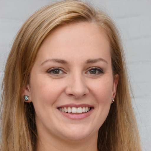 Joyful white young-adult female with long  brown hair and blue eyes