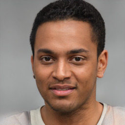 Joyful black young-adult male with short  black hair and brown eyes