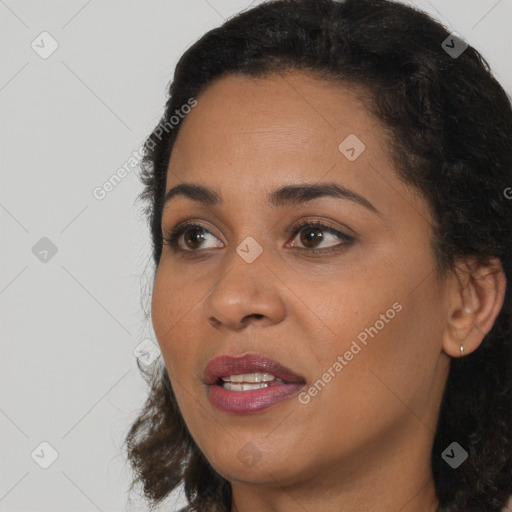 Joyful black young-adult female with long  brown hair and brown eyes