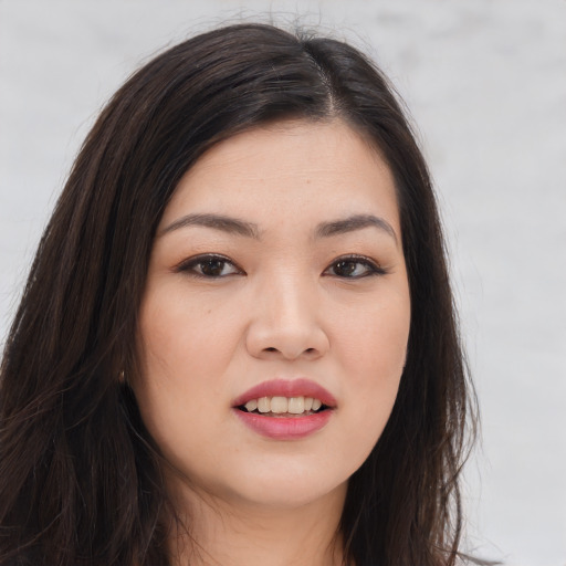 Joyful asian young-adult female with long  brown hair and brown eyes