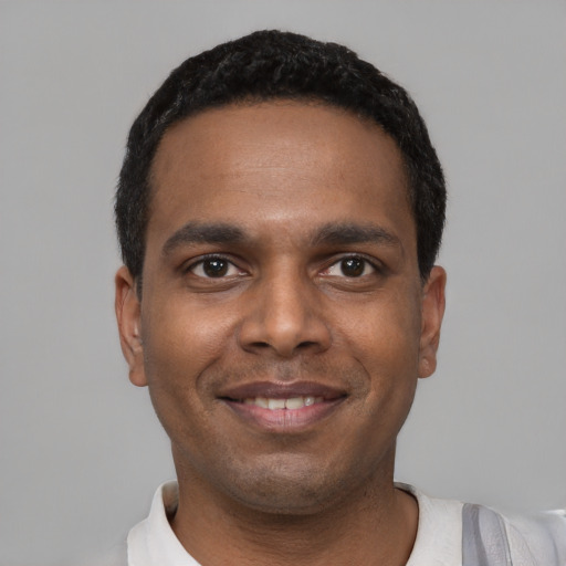 Joyful black young-adult male with short  black hair and brown eyes