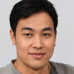 Joyful asian young-adult male with short  brown hair and brown eyes