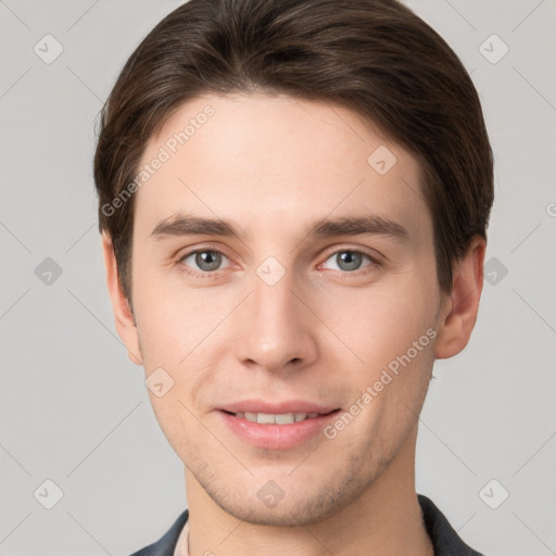 Joyful white young-adult male with short  brown hair and grey eyes