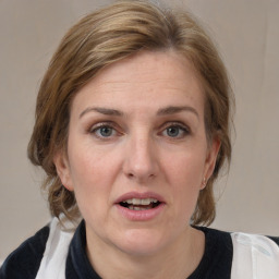 Joyful white adult female with medium  brown hair and grey eyes