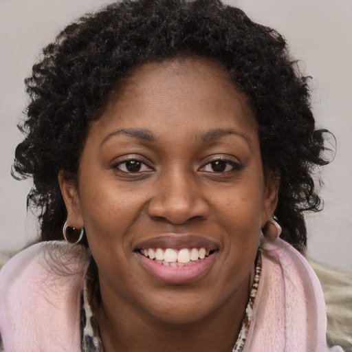 Joyful black young-adult female with long  brown hair and brown eyes