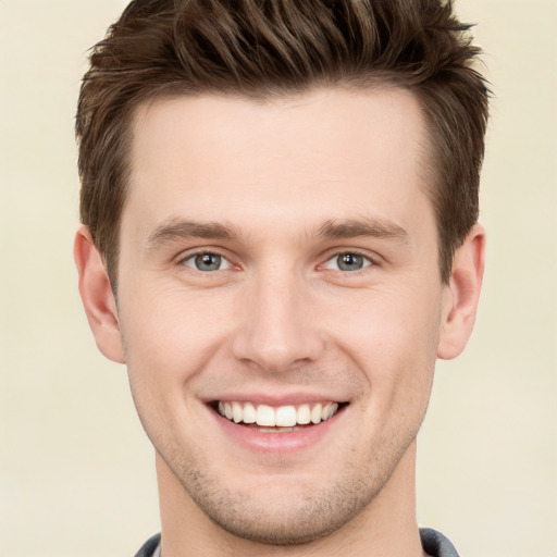 Joyful white young-adult male with short  brown hair and grey eyes