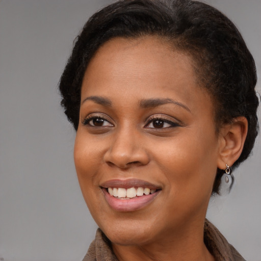 Joyful black young-adult female with long  brown hair and brown eyes
