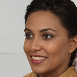 Joyful black young-adult female with long  brown hair and brown eyes