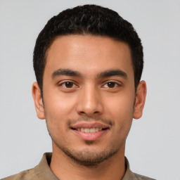 Joyful latino young-adult male with short  brown hair and brown eyes