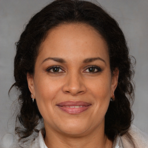 Joyful latino adult female with medium  brown hair and brown eyes