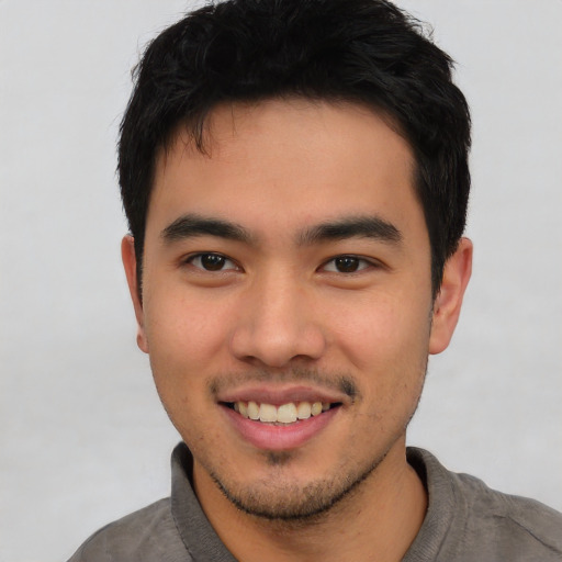 Joyful asian young-adult male with short  brown hair and brown eyes