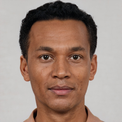 Joyful black adult male with short  black hair and brown eyes