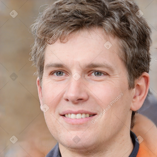 Joyful white adult male with short  brown hair and grey eyes