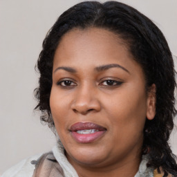 Joyful black young-adult female with long  brown hair and brown eyes