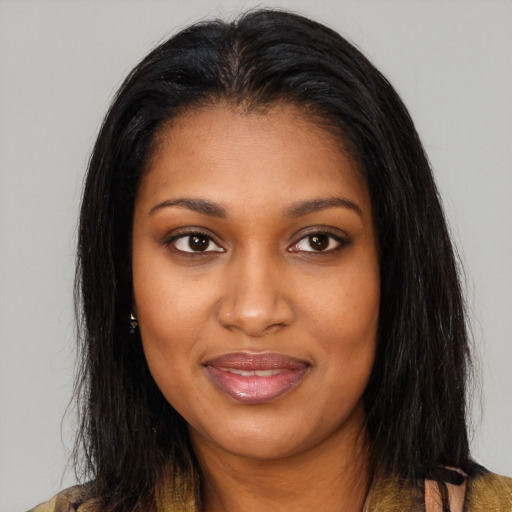 Joyful black young-adult female with long  brown hair and brown eyes