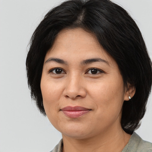 Joyful asian adult female with medium  black hair and brown eyes